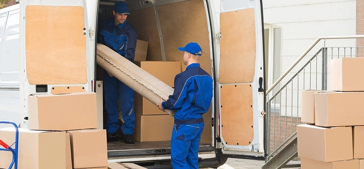 Cheap vs professional movers in Dubai Marina carrying furniture boxes out of apartment